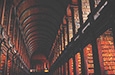 photo of old world library interior with bookshelves receding into the distance